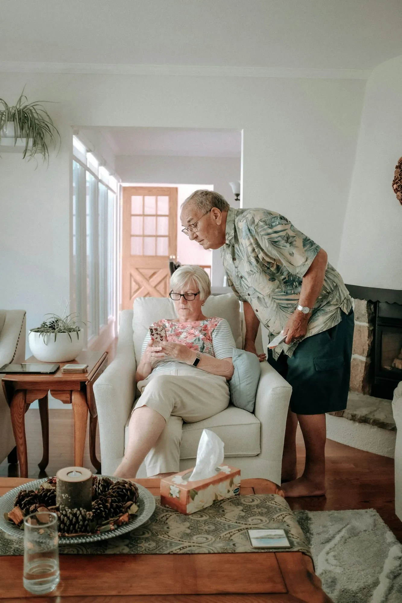 An older couple relaxes in a bright, tidy living room